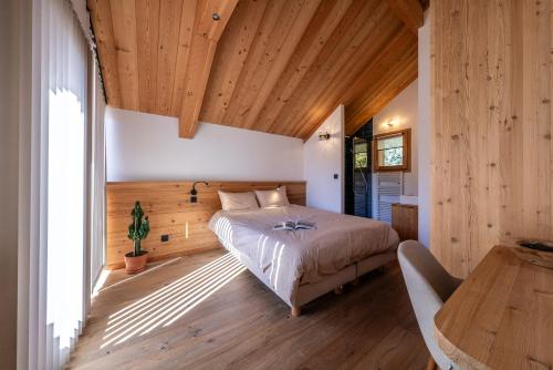 a bedroom with a bed and a wooden ceiling at Chalet Ski Académie - Serre Chevalier in Saint-Chaffrey