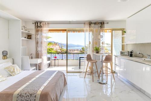 Cet appartement comprend une chambre avec un lit et une cuisine avec vue. dans l'établissement Magnifique studio limitrophe Monaco, parking privé, à Roquebrune-Cap-Martin