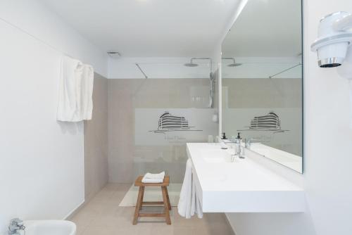 a white bathroom with a sink and a mirror at Hotel Médano in El Médano