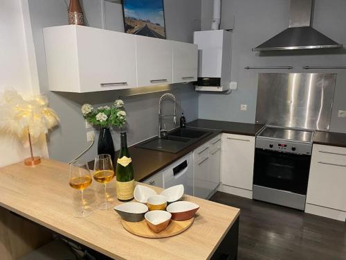 uma cozinha com armários brancos e uma mesa com copos de vinho em La crème de la crème - Chantilly em Chantilly