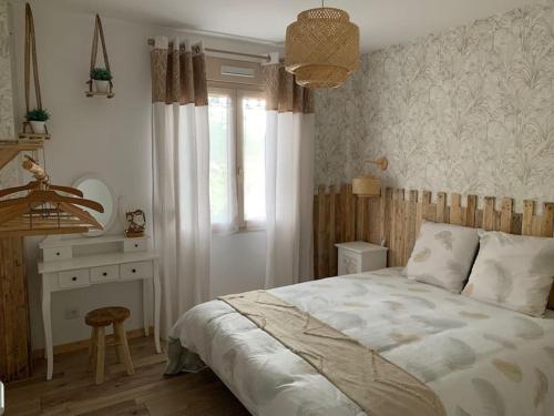 a bedroom with a bed and a desk and a window at Gite de Groupe Aux Instants Partagés in Fontenay-sur-Vègre