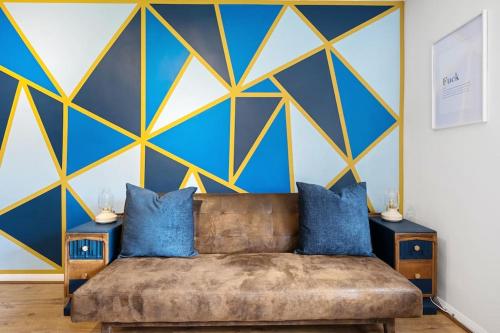 a living room with a couch and a blue and yellow wall at Studio Apartment in Central Maidstone in Kent