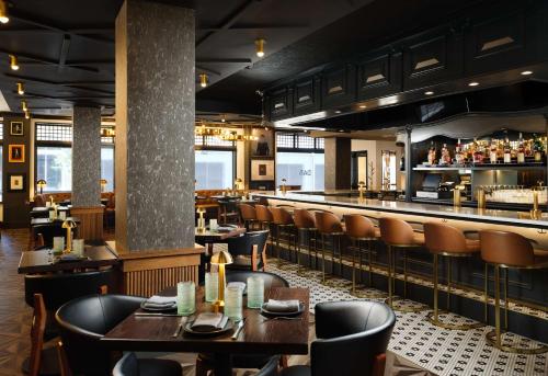 a restaurant with tables and chairs and a bar at Hotel Flor Tampa Downtown, Tapestry Collection By Hilton in Tampa