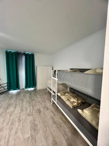 a room with two bunk beds and green curtains at Neuwertiges Apartment mit schnellem WLAN, Glasfaser, Kostenlose Privatparkplatz auch für Transporter geeignet R25 in Freiberg am Neckar