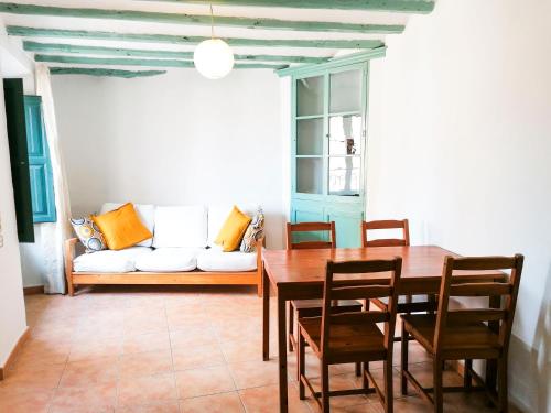 Vila Closa Juncosa في Juncosa: غرفة طعام مع طاولة وأريكة