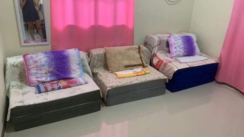 Habitación con 2 camas y 2 reposapiés en Pagadian City House Rental - Hidehouse, en Pagadían​