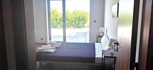een slaapkamer met een bed en een groot raam bij Verdvillage, Lda in Valença