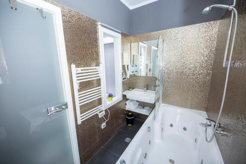 a bathroom with a bath tub and a sink at A Heritage Split in Split