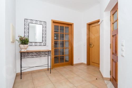 um corredor com uma mesa com um espelho e uma porta em Casa Clajon em Budens