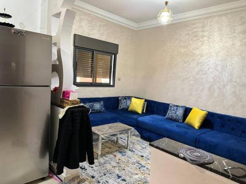 un soggiorno con divano blu e frigorifero di casa hermosa ad Agadir