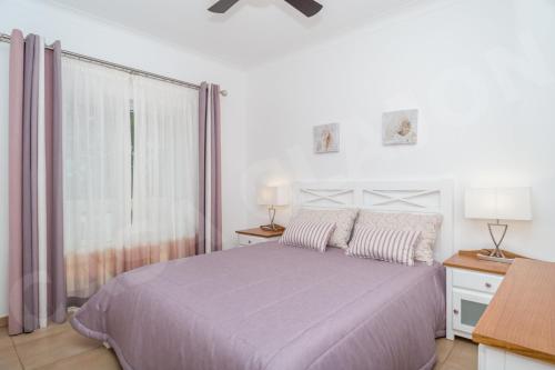 um quarto branco com uma cama e uma janela em Casa Clajon em Budens