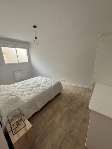 une chambre avec un lit et un parquet dans l'établissement Appartement neuf avec patio, à Saint-Laurent-sur-Sèvre