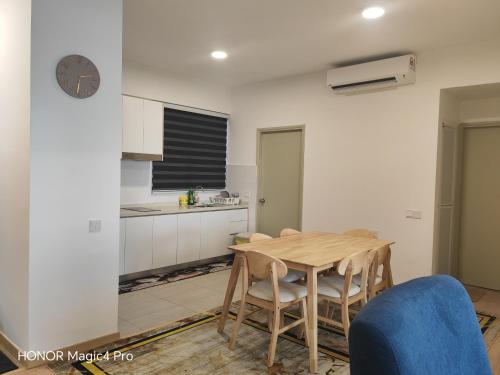 a kitchen and dining room with a wooden table and chairs at Mutiara Melaka Beach Resort Condominium,Pantai Puteri Melaka in Melaka