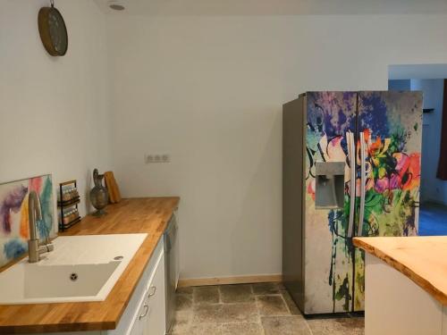 une cuisine avec un évier et un réfrigérateur dans l'établissement paradis perdu piscine jacuzzi billard baby-foot, à Louvie-Juzon