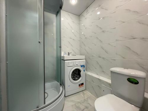 a bathroom with a toilet and a washing machine at 1-комнатная квартира с дизайнерским ремонтов в районе Вокзала in Petropavlovsk