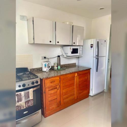 een keuken met witte apparaten en houten kasten bij Zorzal Tempo in Esquel