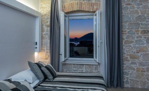 a bedroom with a window with a couch and a view at A Heritage Split in Split