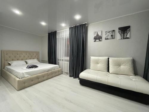 a bedroom with two beds and a window at 1-комнатная квартира с дизайнерским ремонтов в районе Вокзала in Petropavlovsk