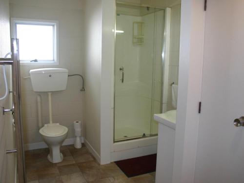 een badkamer met een toilet en een glazen douche bij Mollies Place - Waihi Beach Holiday Unit in Waihi Beach