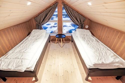 Duas camas num quarto com uma janela em Mountain View Cabin em Pettvik