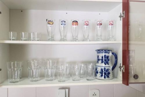 un montón de vasos en un estante en una cocina en Local privilegiado em Aguas ! en Águas de Lindóia