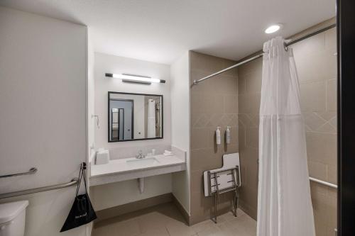 a bathroom with a sink and a mirror and a shower at Spark by Hilton Midland South in Midland