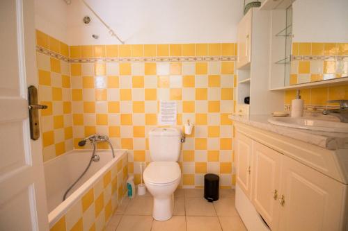 une salle de bain avec toilettes, baignoire et lavabo dans l'établissement Le bois des combes Cottage, à Lorgues