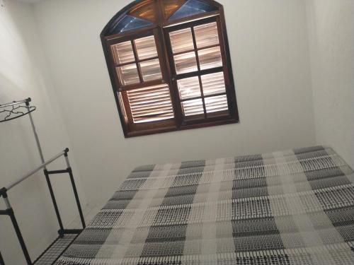 a bedroom with a bed and a window at Casa de praia in Florianópolis