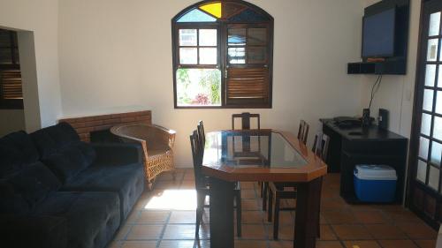 ein Wohnzimmer mit einem Sofa und einem Glastisch in der Unterkunft Casa de praia in Florianópolis