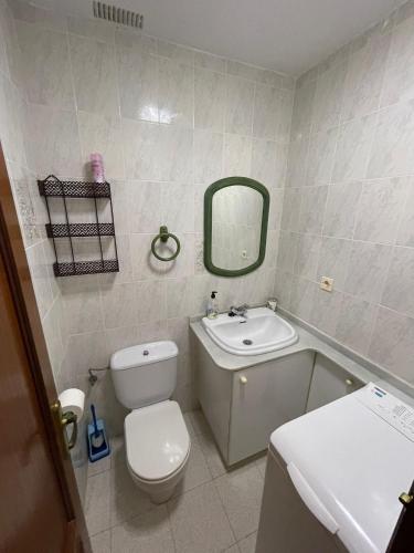 a bathroom with a toilet and a sink and a mirror at NOJALUZ in Noja