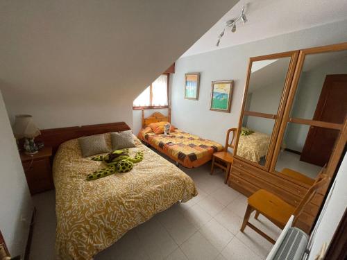 um pequeno quarto com uma cama e um espelho em NOJALUZ em Noja