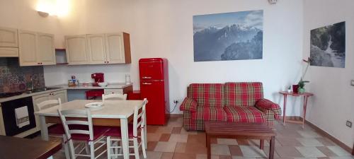 una cucina con tavolo e frigorifero rosso di Casa Gonario a Nuoro