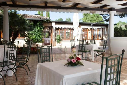 a table with a white table cloth and flowers on it at Monastero Resort & Spa - Garda Lake Collection in Soiano del Lago