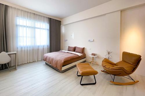 a bedroom with a bed and a chair at Casa de Jumbo in Anping