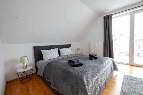 a bedroom with a bed with two black towels on it at FeWo 03 im Carré Charlott in Pulsnitz