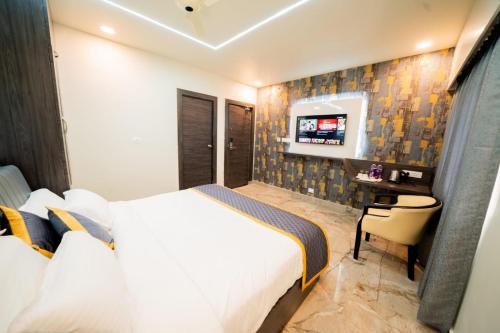 ヴィシャカパトナムにあるBRK ICONIC RESIDENCYのベッドとテレビが備わるホテルルームです。