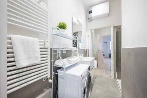 uma casa de banho branca com 2 lavatórios e um espelho em All in One Parma em Parma