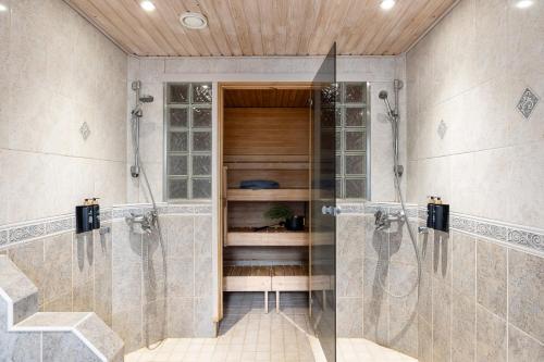 eine ebenerdige Dusche im Bad mit einer Glastür in der Unterkunft Lehmonkärki Resort in Asikkala