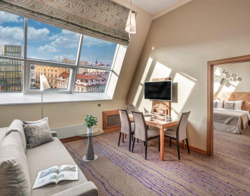 a living room with a couch and a table with chairs at Crown Palace Apartments by Adrez in Prague