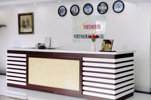 un mostrador en una tienda con relojes en la pared en VIET HOUSE HẠ LONG HOTEL, en Ha Long