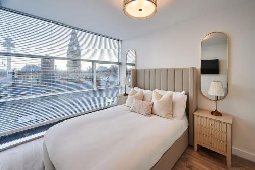 um quarto com uma cama branca e uma grande janela em Host & Stay - The Municipal View Abode em Liverpool