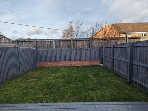 a backyard with a fence and a grass yard at Freshen-up stays Doncaster in Bentley