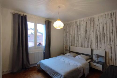 a bedroom with a white bed and a window at Jolie maison modulable de 4 à 6 lits avec jardinet in Irigny