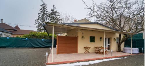 a small house with a porch and a table at Palmy Home Dunakeszi in Dunakeszi