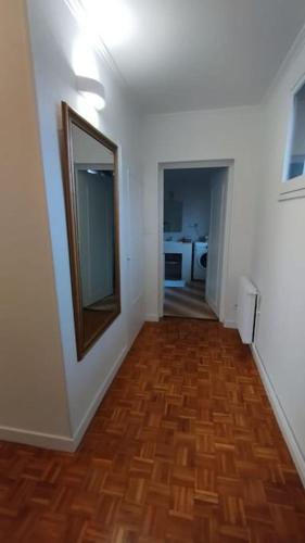 an empty room with a wooden floor and a mirror at Jolie maison modulable de 4 à 6 lits avec jardinet in Irigny