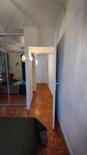 a hallway with a room with a bed and a mirror at Jolie maison modulable de 4 à 6 lits avec jardinet in Irigny