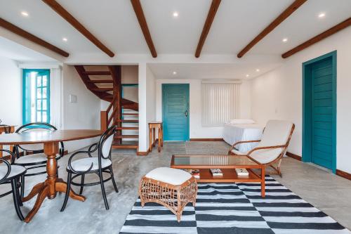 a living room with a table and chairs and a bed at Villa dos Poetas in Barra Grande