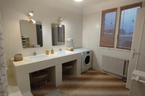 a bathroom with two sinks and a washing machine at Jolie maison modulable de 4 à 6 lits avec jardinet in Irigny