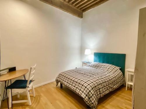 ein Schlafzimmer mit einem Bett, einem Tisch und einem Schreibtisch in der Unterkunft Petit Marin Hyper centre in Lyon