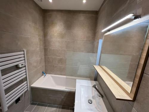 ein Badezimmer mit Badewanne, Waschbecken und Spiegel in der Unterkunft Petit Marin Hyper centre in Lyon